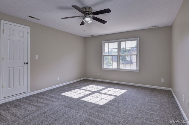 carpeted empty room with a ceiling fan and baseboards