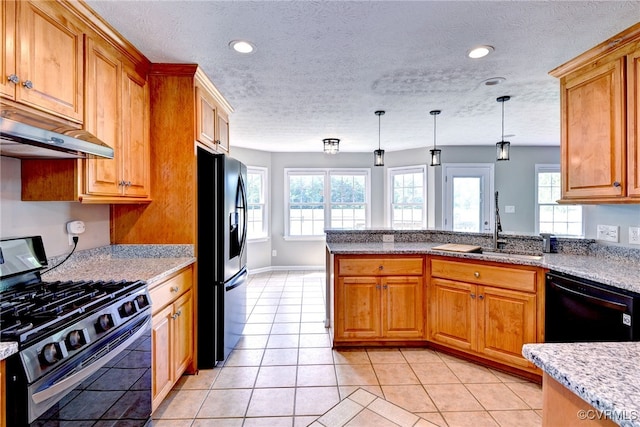kitchen with black appliances, under cabinet range hood, a sink, pendant lighting, and a peninsula
