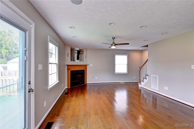 unfurnished living room with hardwood / wood-style floors, healthy amount of natural light, ceiling fan, baseboards, and recessed lighting