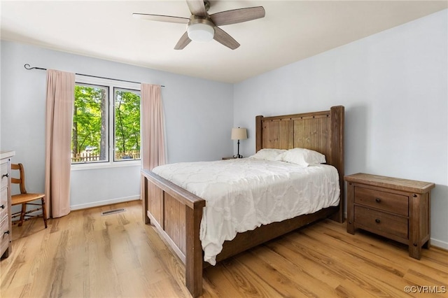 bedroom featuring light wood-style flooring, a ceiling fan, and baseboards