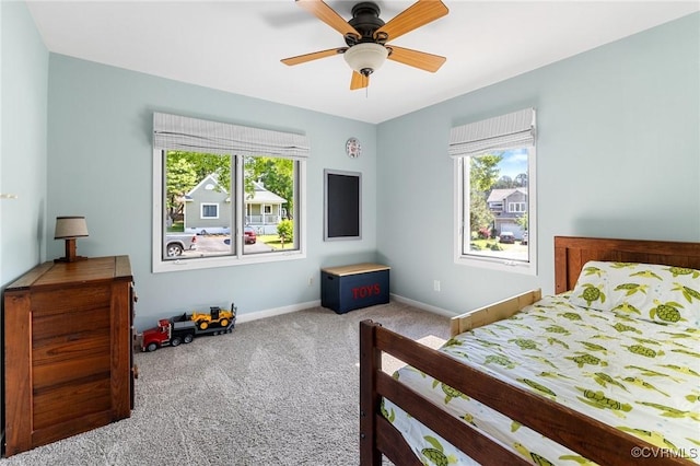 carpeted bedroom featuring baseboards and a ceiling fan