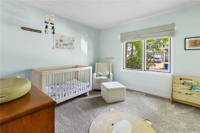 bedroom featuring a nursery area, carpet floors, and baseboards