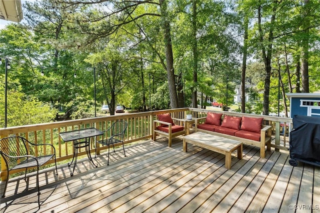 deck with outdoor lounge area and view of scattered trees