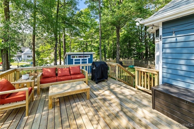 deck featuring grilling area, fence, an outdoor structure, a shed, and outdoor lounge area