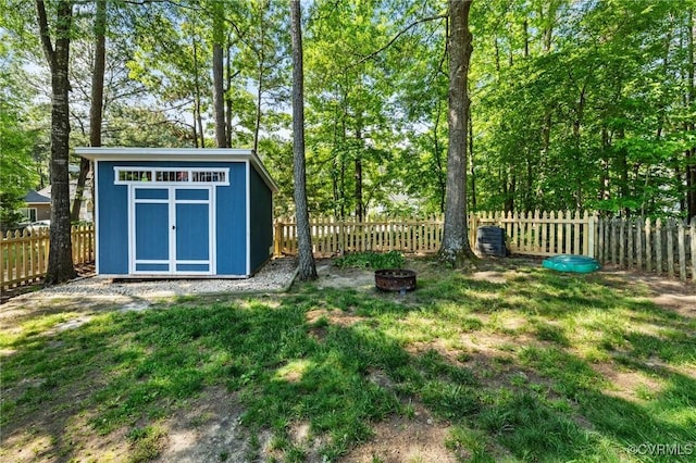 view of yard featuring a storage unit, an outdoor fire pit, and an outdoor structure