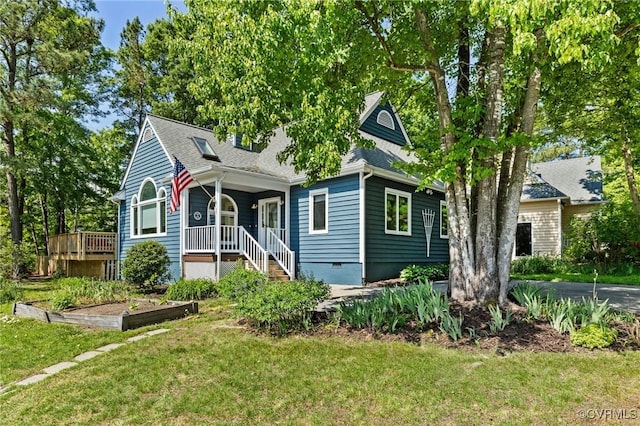 view of front of house with a front yard, a porch, crawl space, a vegetable garden, and a shingled roof