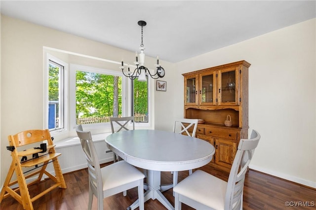 dining area with a chandelier, dark wood-style floors, and baseboards