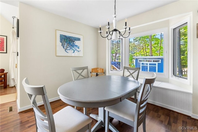 dining area with a chandelier, wood finished floors, and baseboards