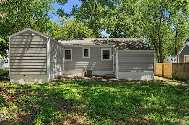 rear view of property featuring crawl space, central AC unit, and a shingled roof