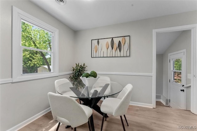 dining space featuring light wood-style flooring and baseboards