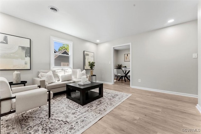 living area with light wood-style flooring, baseboards, and recessed lighting