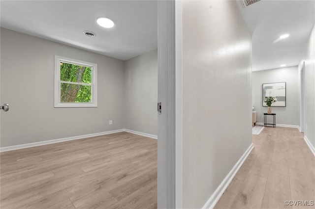 hallway featuring light wood finished floors and baseboards