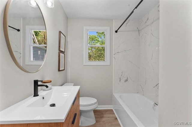 bathroom featuring toilet, vanity, plenty of natural light, and tub / shower combination