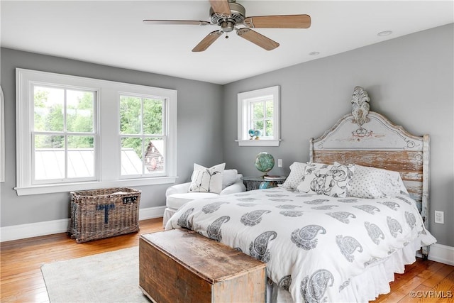bedroom featuring wood finished floors, baseboards, and a ceiling fan