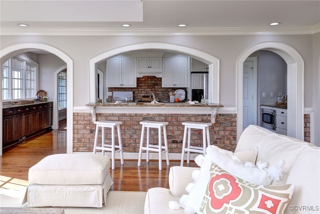 6454 Carmines Island Ln, Gloucester, VA 23072 - living area featuring wood finished floors, crown molding, recessed lighting, and arched walkways
