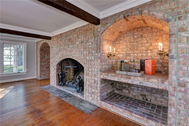 6454 Carmines Island Ln, Gloucester, VA 23072 - unfurnished living room featuring beamed ceiling, wood finished floors, baseboards, and brick wall