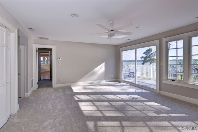 6454 Carmines Island Ln, Gloucester, VA 23072 - unfurnished room with light colored carpet, plenty of natural light, a ceiling fan, and baseboards