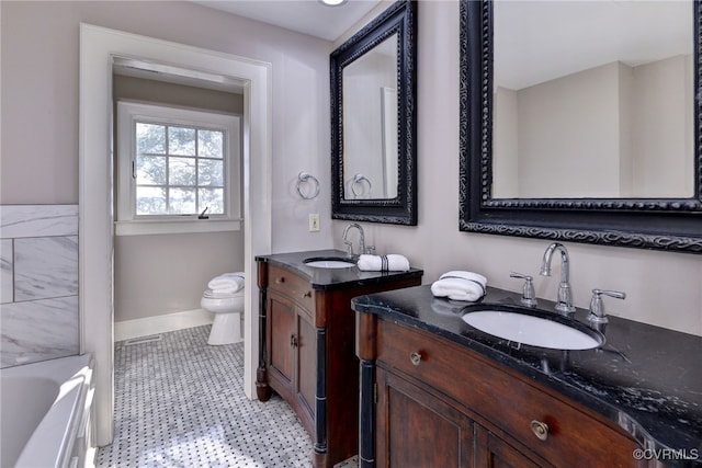 6454 Carmines Island Ln, Gloucester, VA 23072 - bathroom with two vanities, baseboards, and toilet