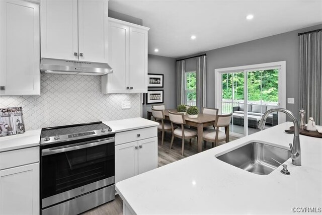 13 Abercrombie Dr, Chesterfield, VA 23838 - kitchen featuring stainless steel electric range oven, under cabinet range hood, a sink, light wood-style floors, and light countertops
