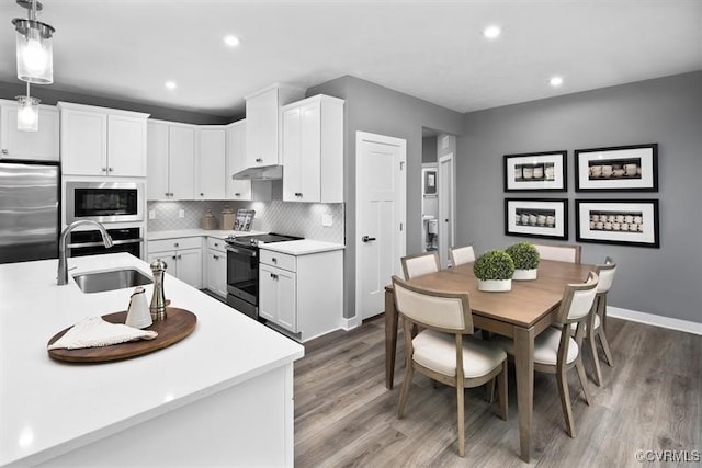 13 Abercrombie Dr, Chesterfield, VA 23838 - kitchen with built in appliances, a sink, wood finished floors, decorative backsplash, and white cabinetry