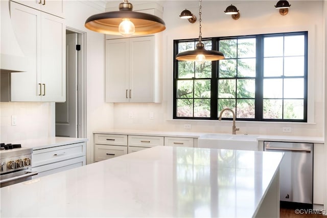 kitchen featuring stainless steel appliances, a sink, light countertops, decorative backsplash, and white cabinets