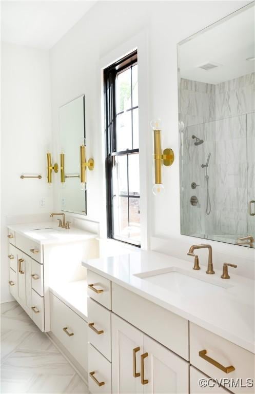 full bathroom with a marble finish shower and vanity