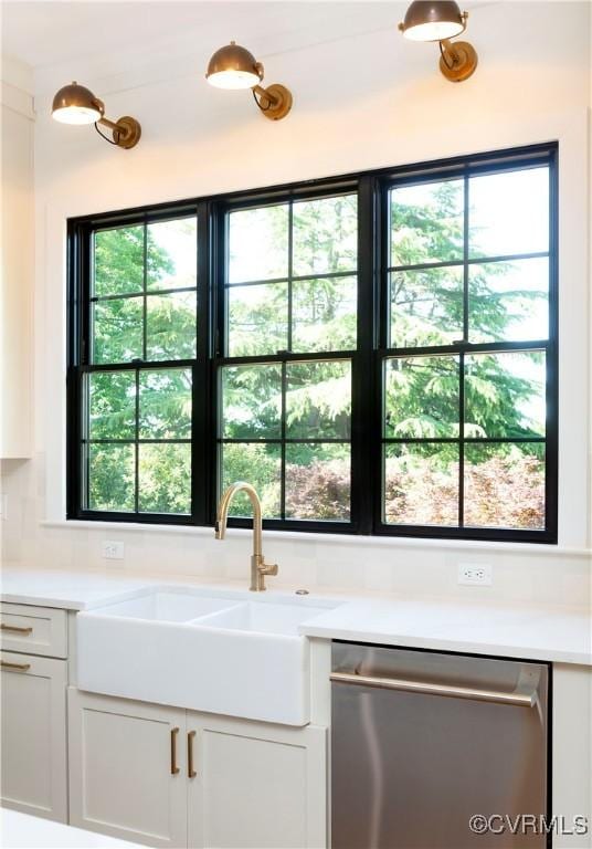 2005 Southcliff Rd, Richmond, VA 23225 - kitchen featuring stainless steel dishwasher, a sink, light countertops, and white cabinetry