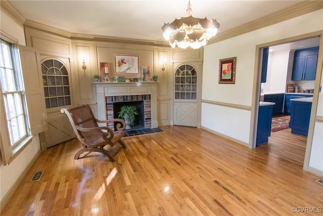 4709 Perdue St, Chester, VA 23831 - living area featuring light wood-style flooring, a chandelier, ornamental molding, a fireplace, and baseboards