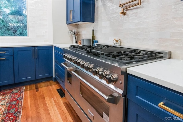 4709 Perdue St, Chester, VA 23831 - kitchen featuring range with two ovens, blue cabinetry, and backsplash