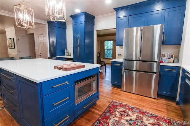 4709 Perdue St, Chester, VA 23831 - kitchen with appliances with stainless steel finishes, blue cabinets, a chandelier, ornamental molding, and light countertops