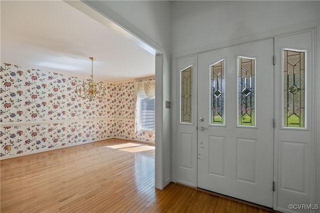 entrance foyer featuring wood finished floors and wallpapered walls