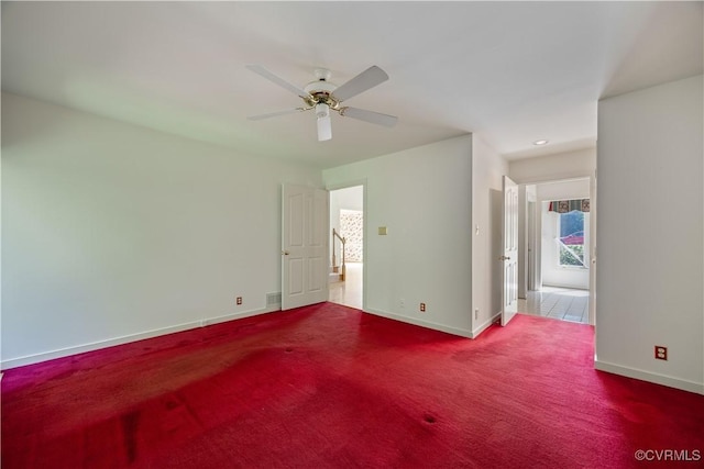 unfurnished room featuring baseboards, ceiling fan, and carpet