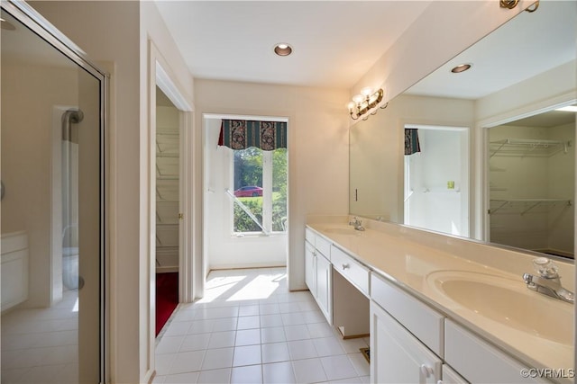 full bath featuring a spacious closet, double vanity, tile patterned flooring, recessed lighting, and an enclosed shower