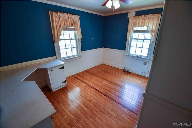 612 S Broad St, Kenbridge, VA 23944 - empty room with healthy amount of natural light, wood-type flooring, ceiling fan, crown molding, and wainscoting