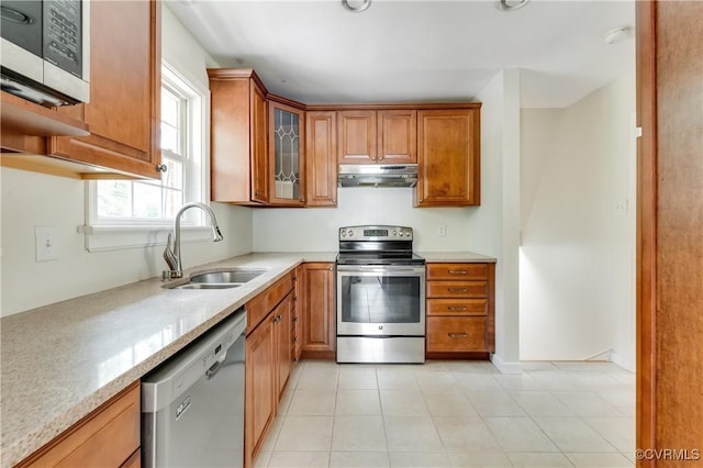 2206 Milbank Rd, Glen Allen, VA 23229 - kitchen with stainless steel appliances, under cabinet range hood, a sink, brown cabinets, and glass insert cabinets