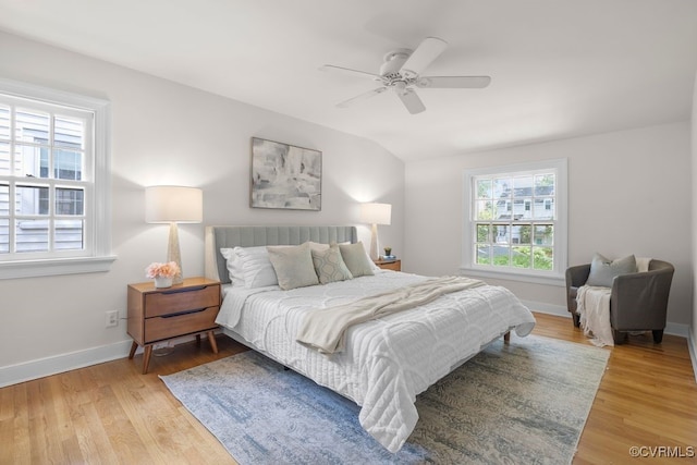 bedroom with light wood-type flooring, baseboards, lofted ceiling, and ceiling fan