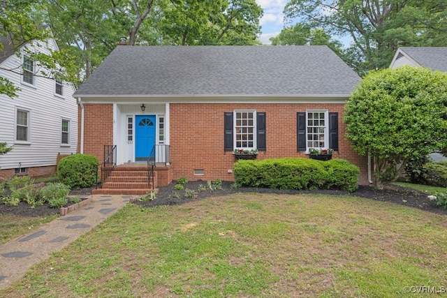 view of front of home with brick siding, a front yard, and a shingled roof