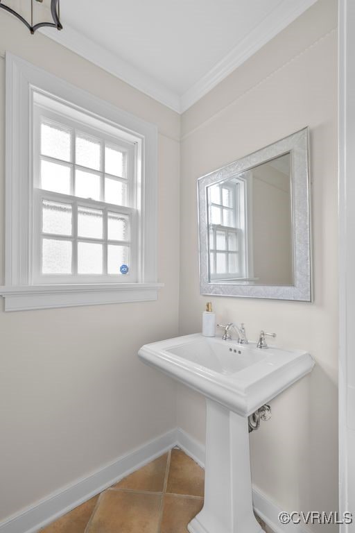 bathroom with baseboards, plenty of natural light, ornamental molding, and tile patterned flooring