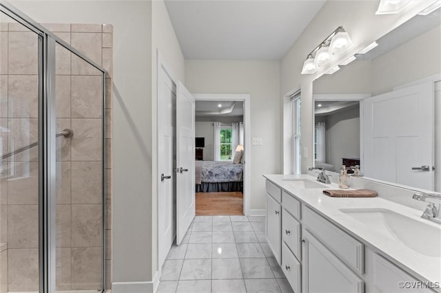 ensuite bathroom featuring a shower stall, double vanity, and baseboards