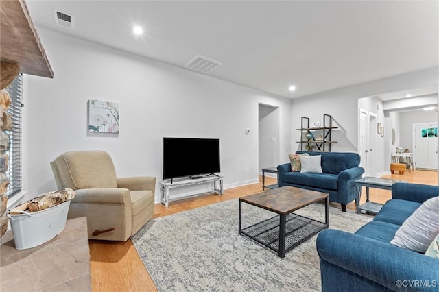 living room featuring light wood-style flooring, recessed lighting, and baseboards