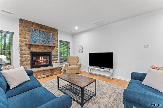 living area with a fireplace, wood finished floors, recessed lighting, and baseboards