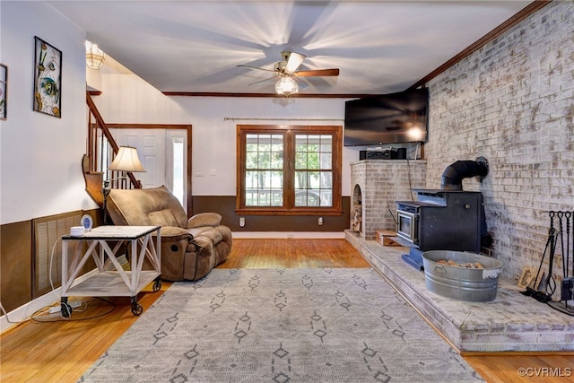 7814 O Neil Rd, Gloucester, VA 23061 - living area featuring a ceiling fan, a wood stove, wood finished floors, wainscoting, and crown molding