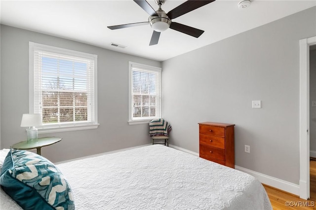 bedroom featuring light wood-style floors, baseboards, and ceiling fan