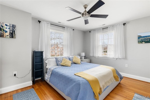 bedroom with baseboards, wood finished floors, and a ceiling fan