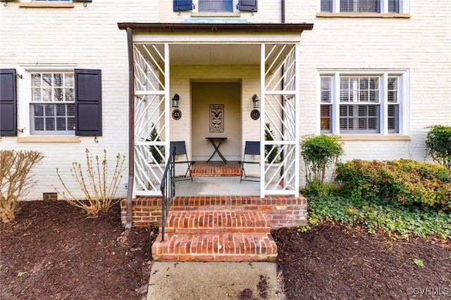 entrance to property with brick siding and covered porch