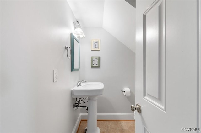 bathroom with baseboards, tile patterned floors, and vaulted ceiling