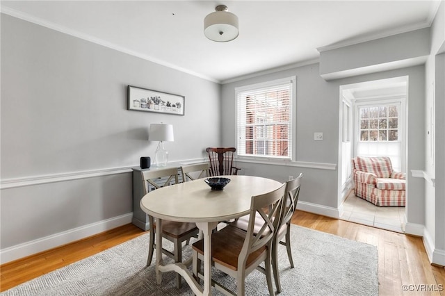 dining room featuring ornamental molding, wood finished floors, and baseboards