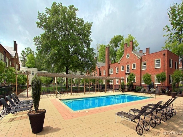 community pool with fence and a patio area
