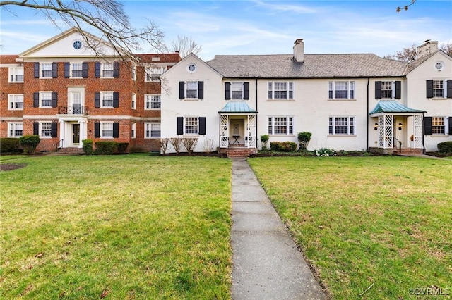 view of front of house with a front yard and a chimney