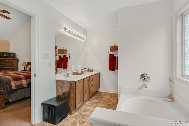 bathroom with connected bathroom, plenty of natural light, ceiling fan, and a bath